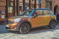 Elegant compact car golden Mini Cooper parked