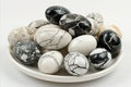 Elegant composition of black and white marble patterned easter eggs on white plate and background