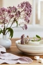 Elegant composition of classy dining room interior design with rustic table, beautiful porcelain, flowers and kitchen accessories. Royalty Free Stock Photo