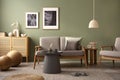 Elegant composition of living room interior. Modern scandi sofa, design pillows, side table, rattan commode and creative personal Royalty Free Stock Photo