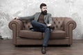 Elegant and confident. Man of fashion. Fashion model relaxing on sofa. Bearded man enjoying casual fashion style Royalty Free Stock Photo