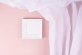 Elegant contemporary gallery in simple style with black square photo frame hanging on soft light pastel pink wall with white silk Royalty Free Stock Photo