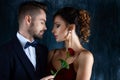 Rich man tempts woman in red evening dress Royalty Free Stock Photo