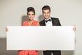Elegant couple smiling while holding a white board Royalty Free Stock Photo