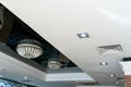 Elegant crystal chandeliers hang on the white ceiling in the lobby of the restaurant. Modern diode lamps inside a retro style lamp