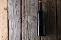 Elegant dark bottle of fragrant red wine on rustic wooden background. Advertising and promotion concept. Mock up. Flat lay. View Royalty Free Stock Photo