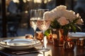 Elegant date table for two with white plates, vine glasses, cooper dishes and bucket with white roses on a bronze color