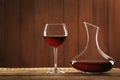 Elegant decanter and glass with red wine on table