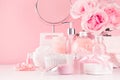 Elegant decor for romantic girlish dressing table - bath, spa cosmetics, accessories, roses bouquet, round mirror in pink color. Royalty Free Stock Photo