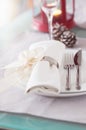 Elegant decorated Christmas table setting with modern cutlery, napkin, bow and christmas decorations