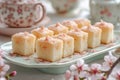 elegant dessert presentation, tiny bento cakes arranged attractively on a flowery platter in a spring setting Royalty Free Stock Photo