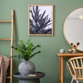 Elegant details of modern interior design with poster in coffe table, round mirror, plant and stylish personal accessories. Wooden