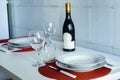 elegant dining table set for two with wine bottle and red placemats Royalty Free Stock Photo