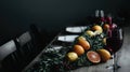 Elegant Dining Table Setup with Citrus Fruits and Red Wine Royalty Free Stock Photo