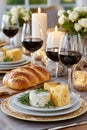 Elegant dinner table setting with red wine, cheese, bread and candles Royalty Free Stock Photo