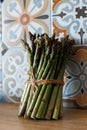 Elegant Display of Tied Asparagus Bundle on Kitchen Table with Colorful Tiles Royalty Free Stock Photo