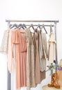 Elegant dress, jumper, trousers and other fashion outfit pastel beige color. Spring cleaning home wardrobe