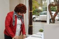 Senior woman checks the money in the cash register