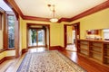 Elegant empty living room with yellow walls, carved wood doorway