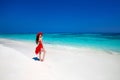 Elegant enjoying woman in red hat and dress resting on tropical Royalty Free Stock Photo