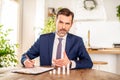 Elegant entrepreneur, businessman, agent looking at camera, signing documents. Man in the suit with the dices on the desk Royalty Free Stock Photo