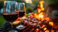 Elegant evening barbecue with red wine and skewers grilling over open flames. Royalty Free Stock Photo