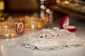 Elegant, expensive two golden wedding rings with pearls on ornated white heart shaped cushion and table closeup Royalty Free Stock Photo