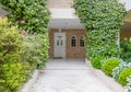 An elegant family house entrance marble covered pathway between the garden to the white door.
