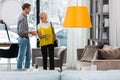 Elegant fancy elderly woman selecting new couch with good-appealing son