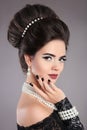 Elegant fashion jewelry woman portrait. Brunette lady with makeup and hairstyle, pearls accessories set posing isolated on studio Royalty Free Stock Photo