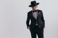 elegant fashion man in black tuxedo with hat holding hands in pockets Royalty Free Stock Photo