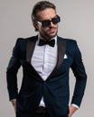 elegant fashion man with sunglasses holding hands in pockets Royalty Free Stock Photo