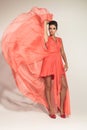 Elegant fashion woman fluttering her coral gown