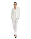 elegant fashion woman in white suit holding hands in pockets and walking Royalty Free Stock Photo