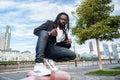 elegant and fashionable young black man of African ethnicity posing crouched looking at the camera Royalty Free Stock Photo