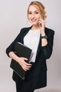 Elegant fashionable young office woman in suit, holding folder, talking on phone isolated on white background. Cheerful Royalty Free Stock Photo