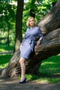 Elegant fashionable young woman standing near big tree Royalty Free Stock Photo