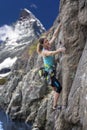 Elegant female alpine climber ascents natural rock