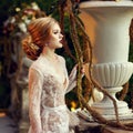 Female model posing beside stone balustrade and large flower vas Royalty Free Stock Photo