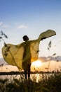 elegant female silhouette stands at sunset , spreading wings against sun