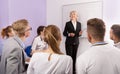 Female teacher lecturing to students at auditorium