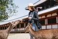 An elegant female tourist feeding grass to deer