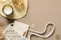 Elegant feminine workspace with boho style macrame handbag, weekly planner, candle, dried flowers on beige table. Top view. Flat Royalty Free Stock Photo