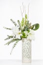Elegant flower arrangement in beautiful vase isolated in a bright white studio