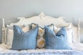 Elegant French country bedroom interior with blue decorative pillows on bed Royalty Free Stock Photo