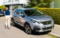 Elegant French woman walking near beautiful Peugeot 3008 crossover SUV