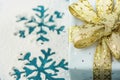 Elegant Gift Box Wrapped in Grey Silver Paper with Polka Dots Golden Ribbon on Snowy Background with Blue Snow Flakes. Christmas Royalty Free Stock Photo