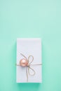 Elegant Gift Box Wrapped in White Paper Tied with Twine Pink Bauble Hanging. Christmas New Years Presents Shopping Sale.