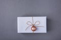 Elegant Gift Box Wrapped in White Paper Tied with Twine Pink Christmas Tree Ball Hanging. New Years Presents Shopping Sale