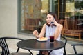 Elegant girl calling someone while resting in outdoor cafe Royalty Free Stock Photo